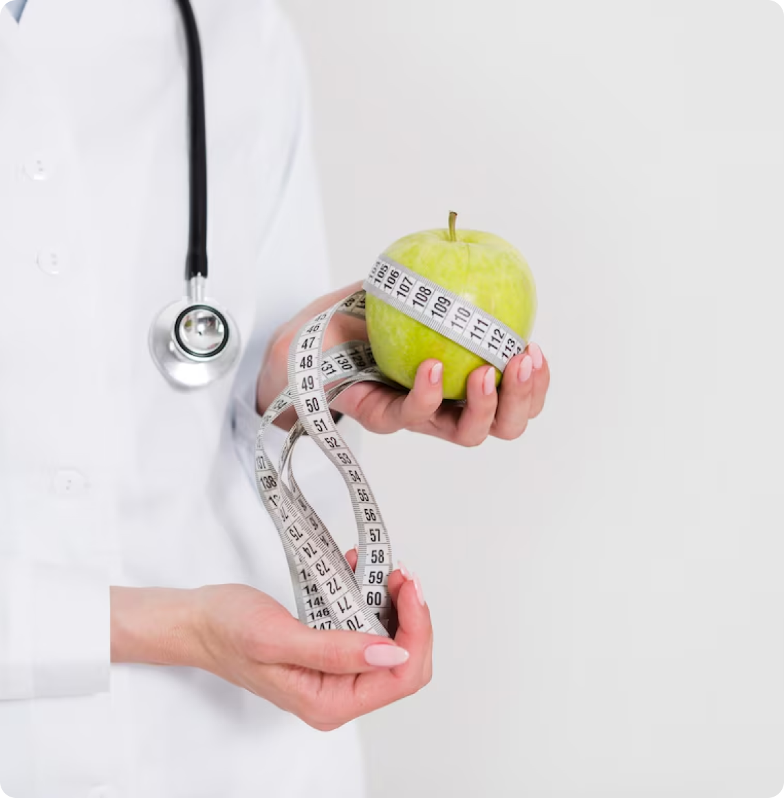 Hands measuring an apple with a tape measure while holding a stethoscope.