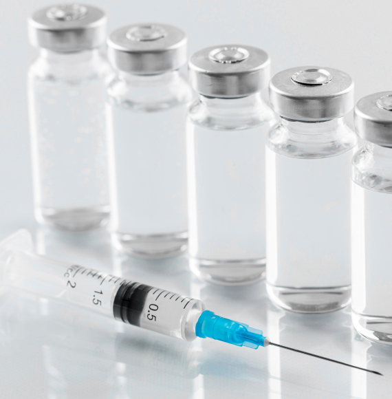 Vials of injectable medication with syringe in foreground
