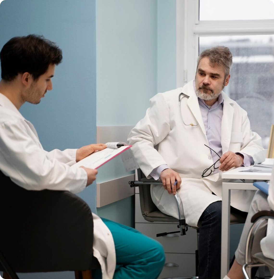 Two medical professionals reviewing patient records in a clinical setting.